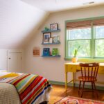 Bed, desk and shelves in a colorful kids room.