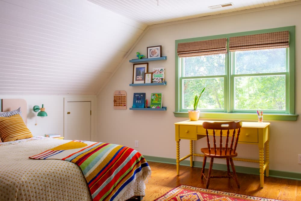 Bed, desk and shelves in a colorful kids room.