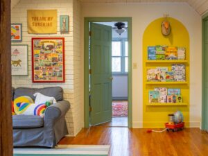 Colorful playroom with a yellow bookshelf and a gallery wall