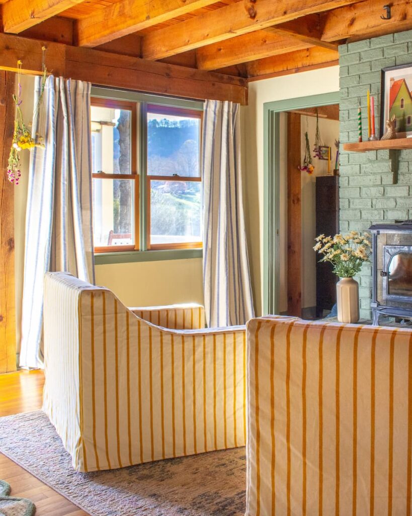 Yellow stripe chairs in a sitting room with a green fireplace