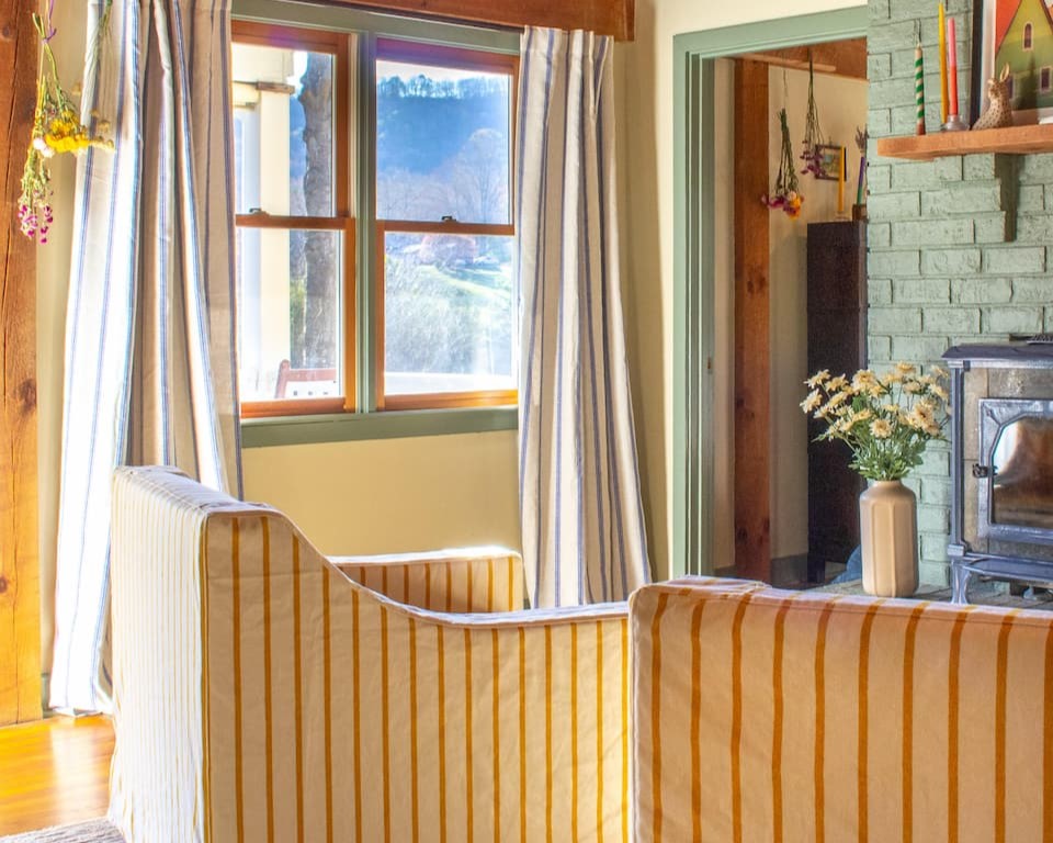 Yellow stripe chairs in a sitting room with a green fireplace