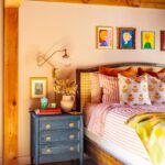 Image of a bed with striped bedding and a blue nightstand.