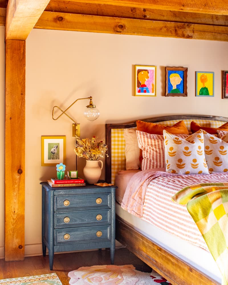 Image of a bed with striped bedding and a blue nightstand.