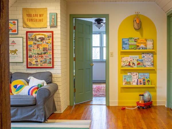 Colorful playroom with a yellow bookshelf and a gallery wall